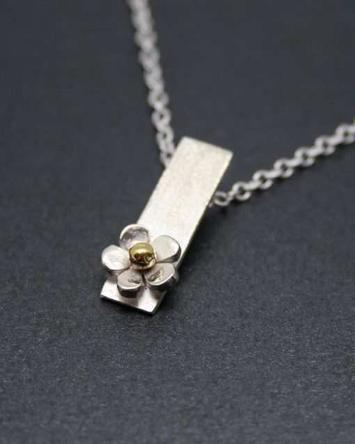 silver daisy drop necklace with a brass centre