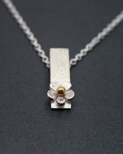 silver daisy drop necklace with a brass centre